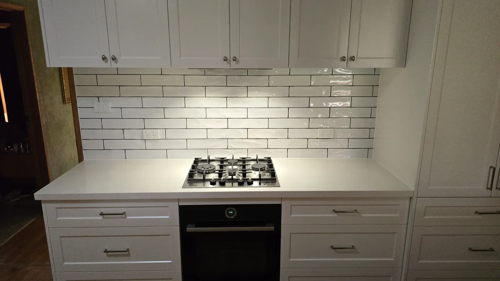 white shaker cabinets, gas cooktop and a subway tile backsplash